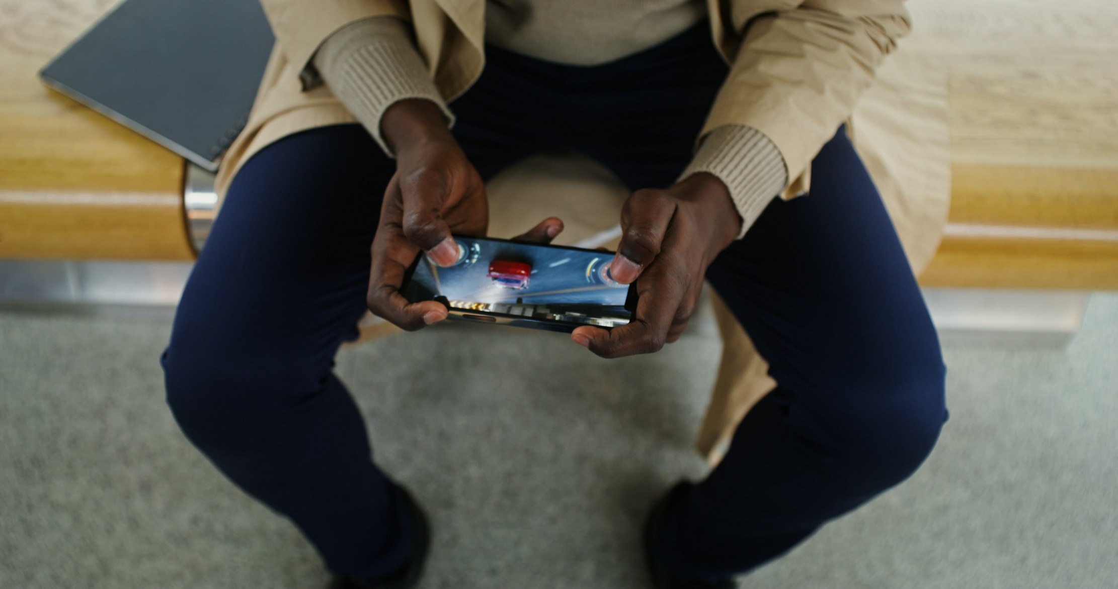 Hands holding a mobile phone during online gameplay